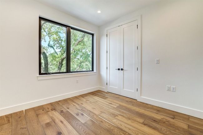 Unfurnished bedroom with light wood finished floors, baseboards, and recessed lighting | Image 31