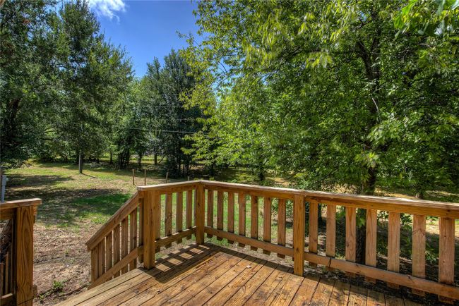 Deck featuring view of wooded area and a yard | Image 24