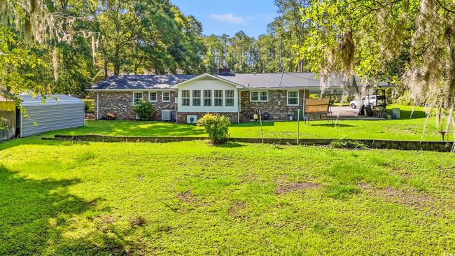 Rear view of property featuring a chimney, a yard, an outdoor structure, and brick siding | Image 27