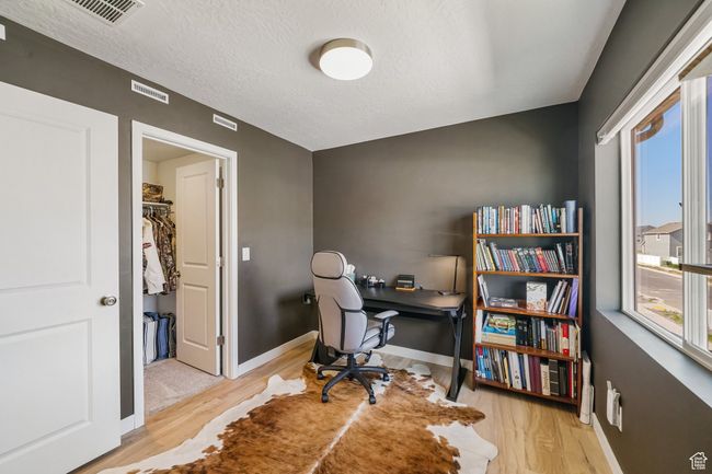 Office area with healthy amount of natural light, wood finished floors, baseboards, and a textured ceiling | Image 26