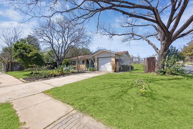 Ranch-style house featuring an attached garage, concrete driveway, a front yard, and fence | Image 29