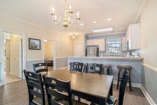 Dining area with a chandelier, crown molding, light wood-style floors, baseboards, and recessed lighting | Image 5