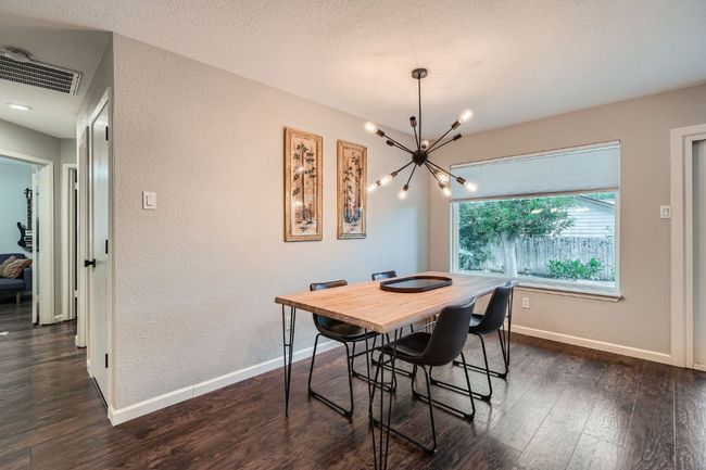 Dining area with a chandelier, a textured wall, and dark wood-style flooring | Image 13