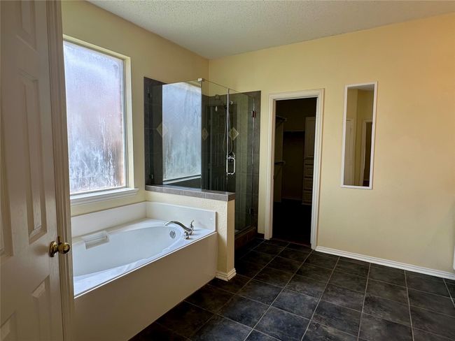 Bathroom featuring a garden tub, a shower stall, a walk in closet, a textured ceiling, and tile patterned flooring | Image 10