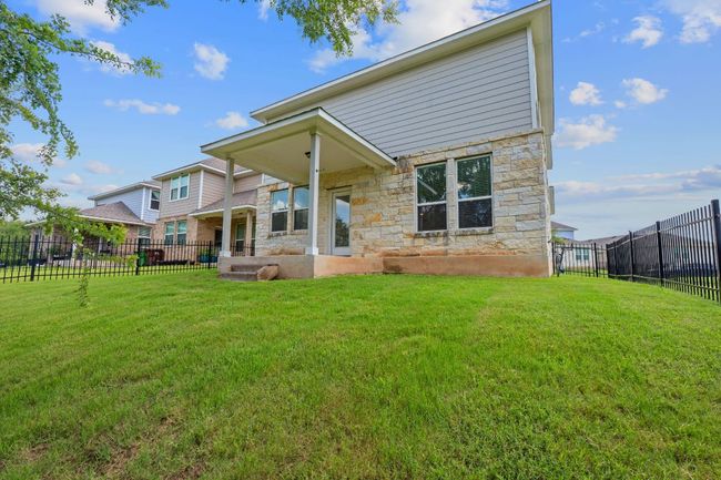 Back of property with stone siding and a fenced backyard | Image 33