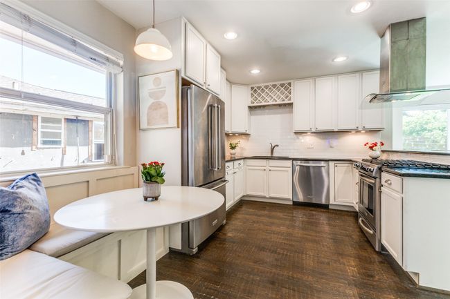 Kitchen featuring stainless steel appliances, range hood, tasteful backsplash, white cabinetry, and recessed lighting | Image 11