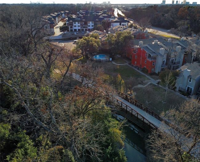 Drone view of back of building from above the creek toward Lake Highlands Trail bridge and downtown Dallas in the distance | Image 4