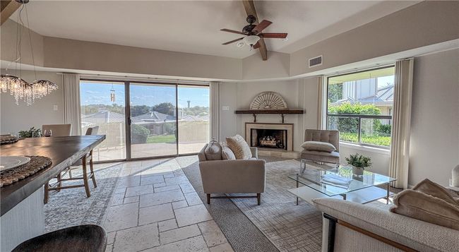 Living room with an abundance of natural lighting and scenic views of courtyard and pool | Image 6