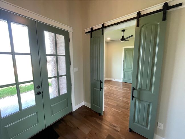 Doorway featuring a barn door, dark wood-style floors, and french doors | Image 33