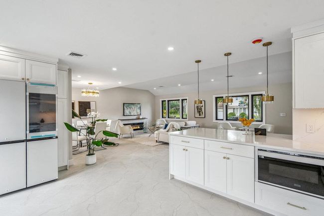 Kitchen featuring a peninsula, stainless steel Appliances, backsplash, white Custom made cabinetry | Image 7