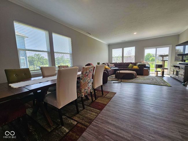 dining space featuring wood finished floors, ornamental molding, a textured ceiling, and recessed lighting | Image 13