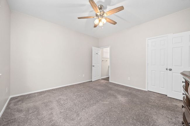 Unfurnished bedroom with carpet, ceiling fan, and baseboards | Image 24