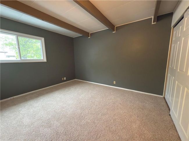Carpeted spare room featuring beam ceiling and baseboards | Image 13