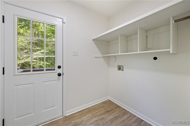 Laundry area featuring electric dryer hookup, light wood-style floors, baseboards, laundry area, and washer hookup | Image 18