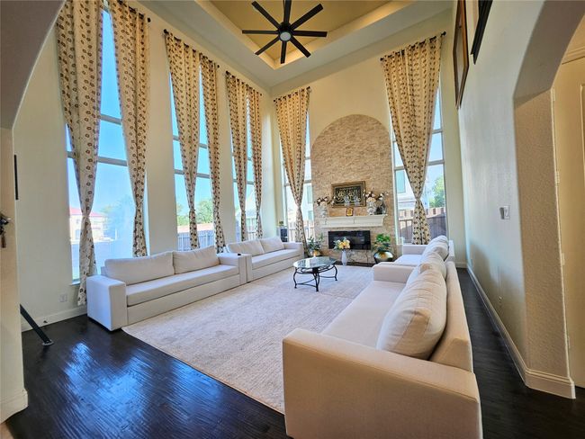 Living room featuring healthy amount of natural light, baseboards, dark wood-style flooring, and a high ceiling | Image 6