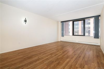 Spare room featuring baseboard heating and dark hardwood / wood-style floors | Image 3