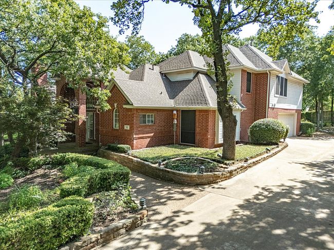 View of front of house featuring driveway, roof with shingles, brick siding, and an attached garage | Image 4