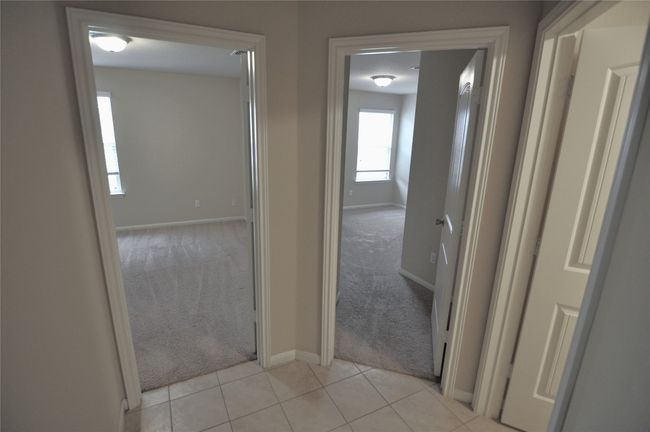 Corridor featuring light colored carpet, light tile patterned floors, and baseboards | Image 6