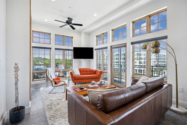 Living room featuring healthy amount of natural light, a towering ceiling, ceiling fan, and recessed lighting | Image 4