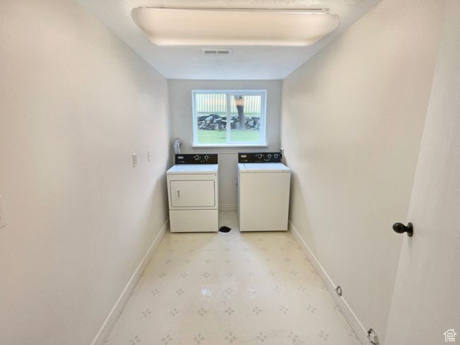 Laundry room with light floors, laundry area, visible vents, independent washer and dryer, and baseboards | Image 22