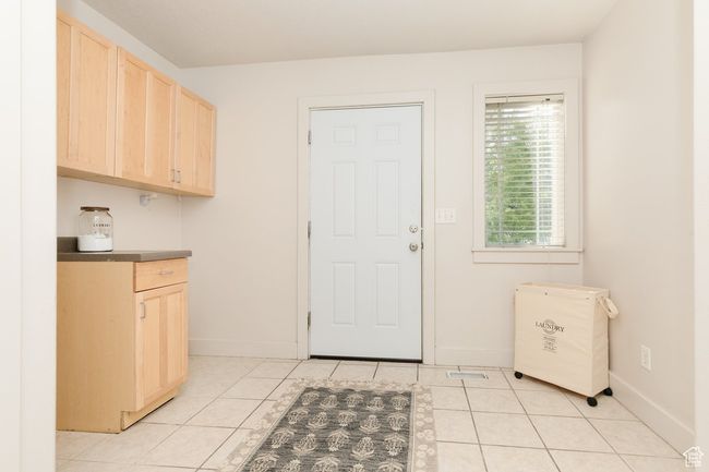 Laundry room with light tile patterned flooring and baseboards | Image 20