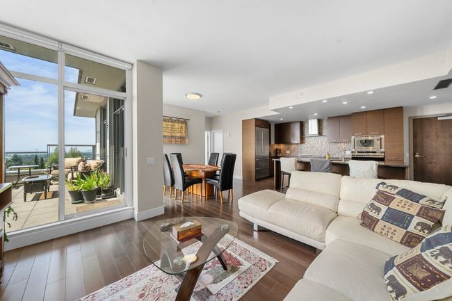 Living area with dark wood-style flooring, a wall of windows, and recessed lighting | Image 6
