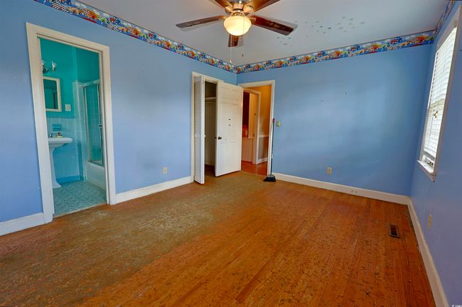 Unfurnished bedroom featuring multiple windows, wood finished floors, a closet, and ensuite bath | Image 21