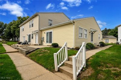 View of side of home with a lawn and a patio area | Image 1