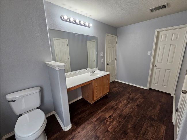 Bathroom with wood finished floors, vanity, and a textured ceiling | Image 16