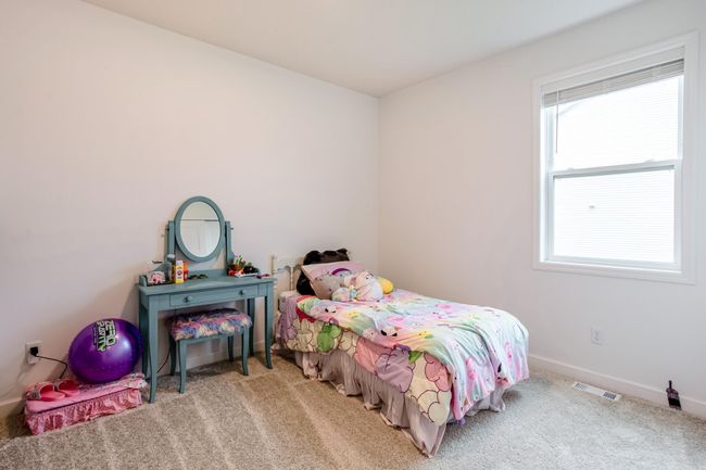 Charming and bright, this bedroom is perfect for play or rest, featuring a large window and cozy carpeting. | Image 26