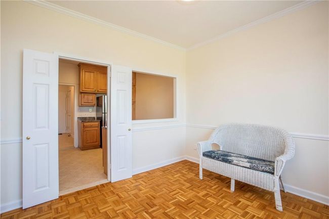 View from the Dining Room with the pass-through into the Kitchen. Throughout the unit, interior doors have been upgraded to panel colonial doors. This room can also serve as an Office or Guest BR. | Image 10