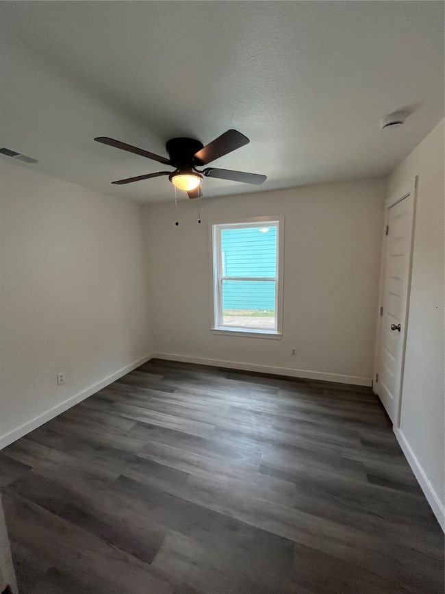 Unfurnished room with a ceiling fan, baseboards, and dark wood-style flooring | Image 7