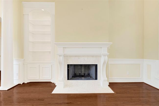 Elegant den with a classic fireplace, perfect for cozy gatherings. | Image 10