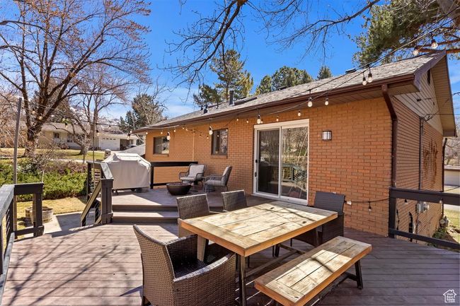 Wooden terrace featuring area for grilling and outdoor dining area | Image 31