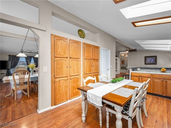 Dining room featuring light wood-type flooring and lofted ceiling with skylight | Image 25