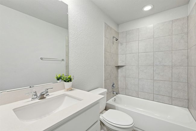 Bathroom with a textured wall, vanity, bathing tub / shower combination, and recessed lighting | Image 34