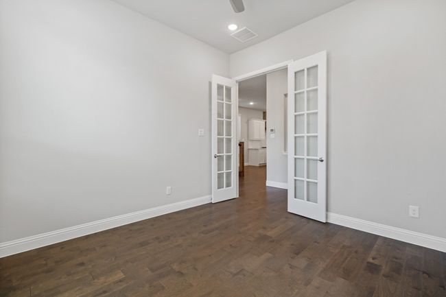 Spare room featuring french doors, dark wood-type flooring, baseboards, visible vents, and a ceiling fan | Image 5