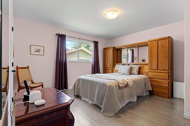 Bedroom with light wood-type flooring | Image 23
