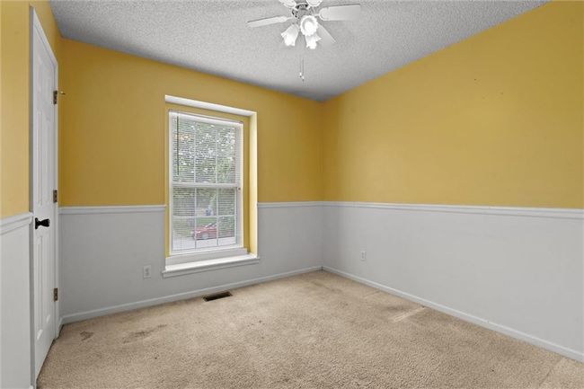 Empty room featuring a textured ceiling, a ceiling fan, and carpet flooring | Image 26