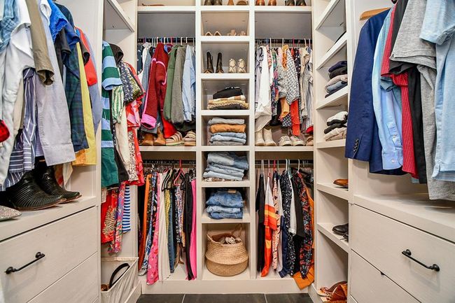 This photo showcases a spacious, well-organized walk-in closet featuring ample hanging space, shelves for folded clothes, and drawers for storage. Ideal for keeping your wardrobe tidy and accessible. | Image 27