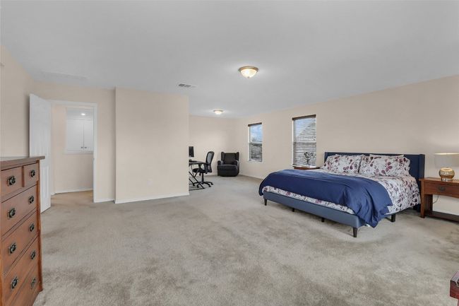 Carpeted bedroom with baseboards and an office area | Image 25