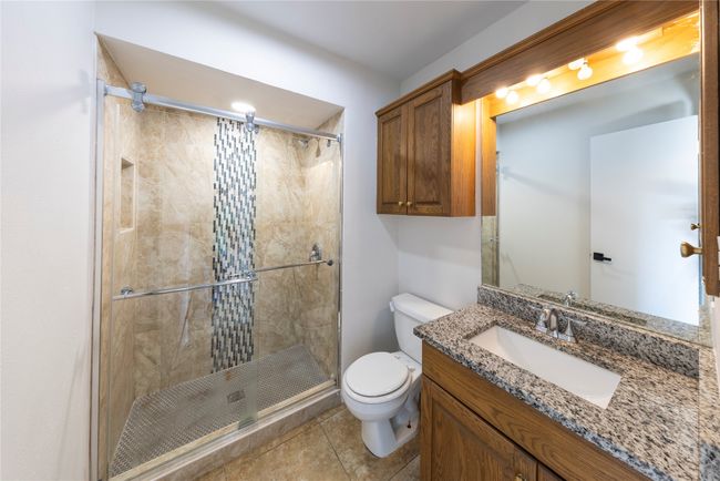 Bathroom in primary bedroom offers artistic styled shower. | Image 17