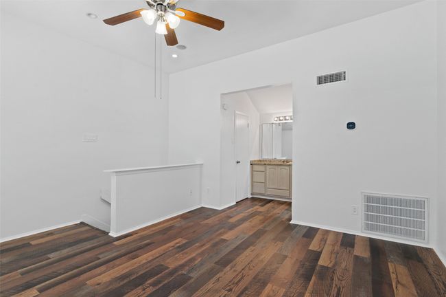 Upstairs bedroom with ensuite bath, ceiling fan and wood like flooring. | Image 20