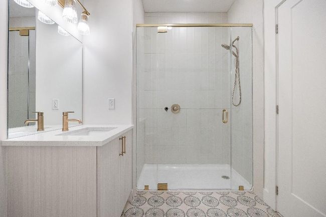 Full bathroom featuring a shower stall, vanity, and tile patterned floors | Image 29