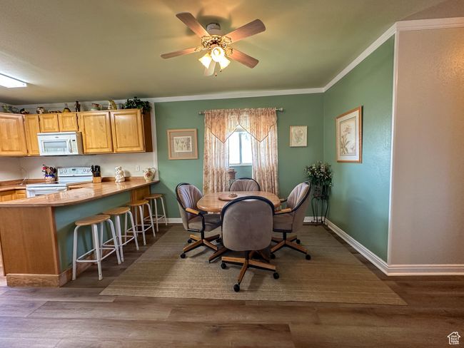 Dining room featuring ornamental molding, wood finished floors, and ceiling fan | Image 12