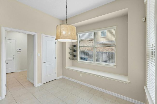 Unfurnished dining area with light tile patterned floors and baseboards | Image 9