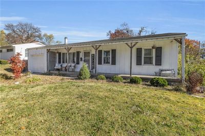 Ranch-style house with a front lawn, covered porch, and a garage | Image 3