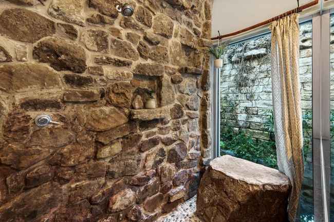 Moss rock wall double head shower with accent rock. | Image 26