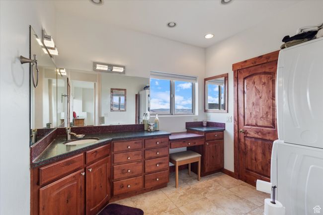 Bathroom featuring vanity, tile patterned flooring, stacked washer and clothes dryer, and recessed lighting | Image 12