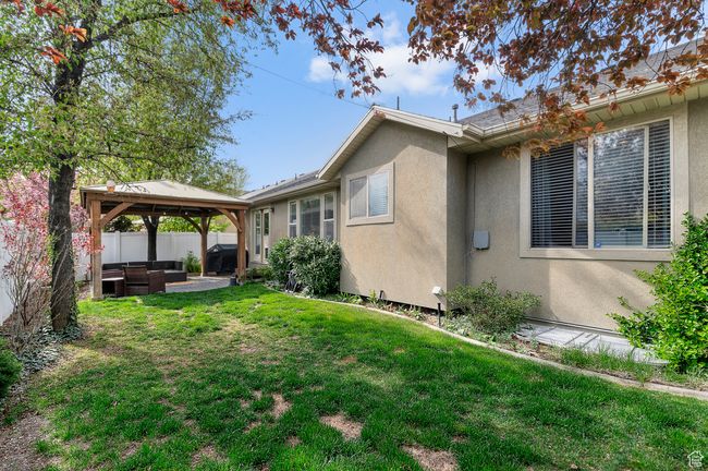 View of property exterior with a lawn, outdoor lounge area, a gazebo, and stucco siding | Image 20